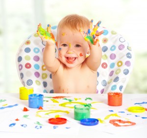 happy child draws with colored paints hands